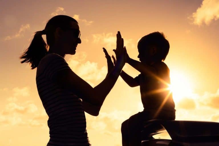 a woman and child giving each other a high five